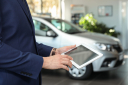 Young,Car,Salesman,With,Tablet,In,Dealership,,Closeup