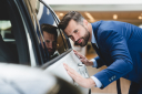 Young,Successful,Caucasian,Businessman,Checking,New,Car,Options,At,Dealer